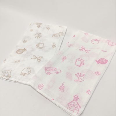 Duas fraldas brancas com desenhos infantis em bege e rosa.