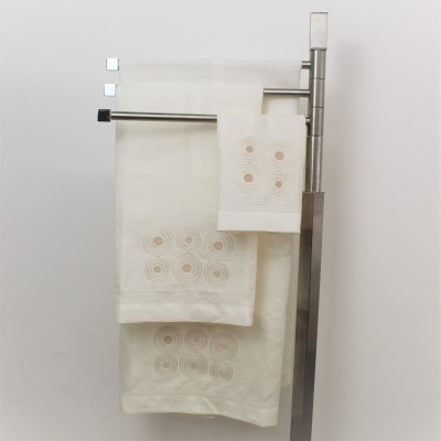 Conjunto de panos de cozinha brancos com bordados pendurados num suporte metálico