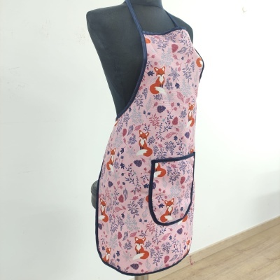Avental rosa com estampado de raposas laranja e flores, com bolso azul escuro