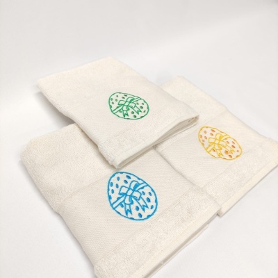 Três toalhas brancas com bordados coloridos circulares