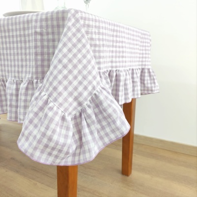 Toalha de mesa xadrez lilás e branco com babados em mesa de madeira