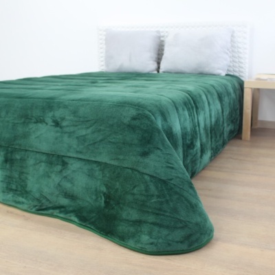 Cama com edredão verde escuro e cabeceira branca trançada