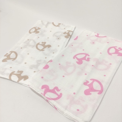 Dois panos brancos com padrão de cavalinhos de balanço rosa e bege