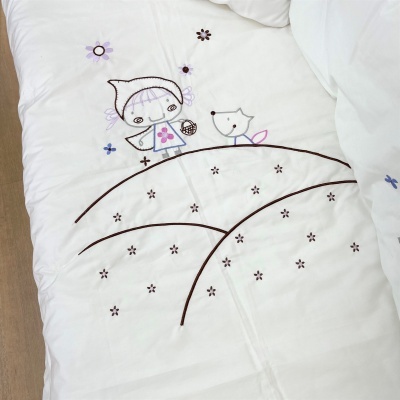 Cobertor branco para criança com bordados coloridos de menina, cão e flores.