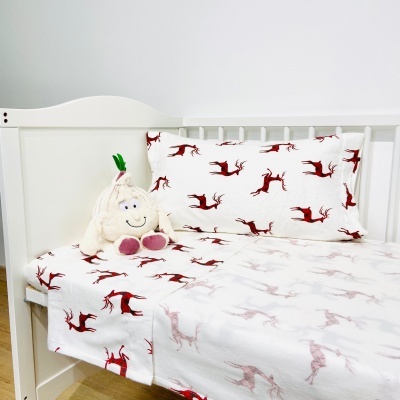 Conjunto de roupa de cama para criança com padrão de veados vermelhos e peluche branco sobre berço branco