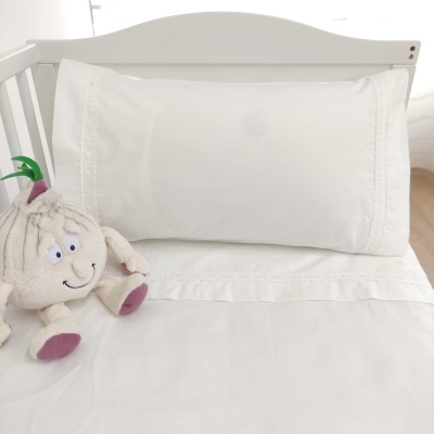 Conjunto de roupa de cama branca com peluche em forma de bolbo.