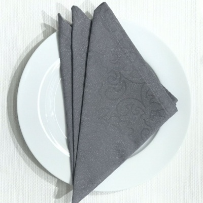 Guardanapo cinzento escuro com padrão floral sobre prato branco