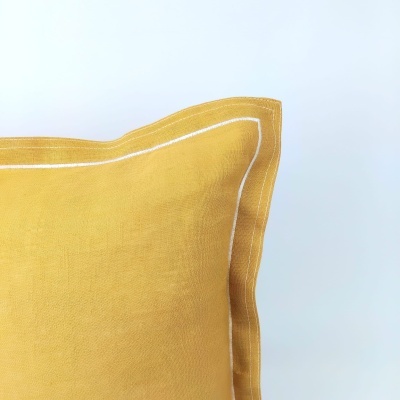 Almofada amarela com costura branca em fundo branco
