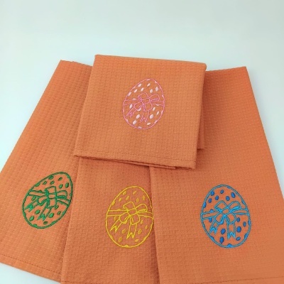 Panostringueiros laranjas com bordados de ovos coloridos