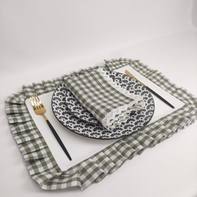 Conjunto de prato, guardanapo, jogo americano às quadrículas verdes e brancas, e talheres preto e dourado