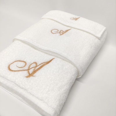 Três toalhas brancas com bordado dourado letra A
