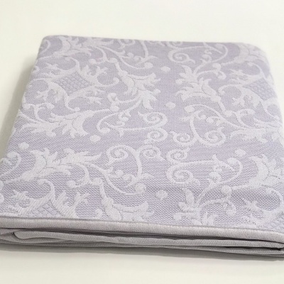 tecido lilás com padrão floral branco dobrado sobre superfície branca