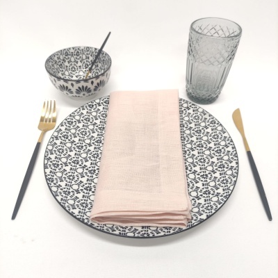 Conjunto de jantar com prato, taça, talheres, guardanapo e copo em fundo branco