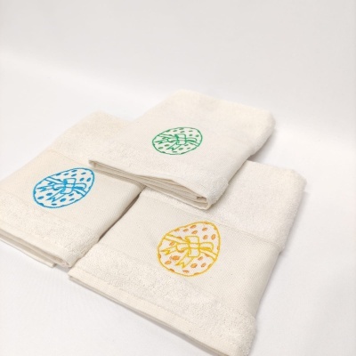 Toalhas brancas com bordados coloridos de folhas