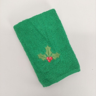 Toalha verde com decoração de folhas e frutas vermelhas