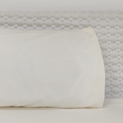 Travesseiro branco sobre superfície branca com padrão texturizado