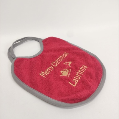 Babete vermelho com bordas cinzentas e texto dourado Merry Christmas Laurinha