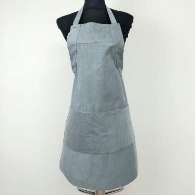 Avental cinzento com bolso frontal amarrado ao pescoço num manequim preto