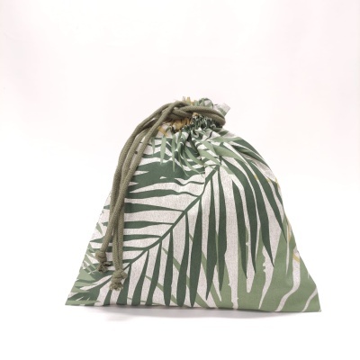 Bolsa em tecido verde com padrão de folhas e cordão de fecho