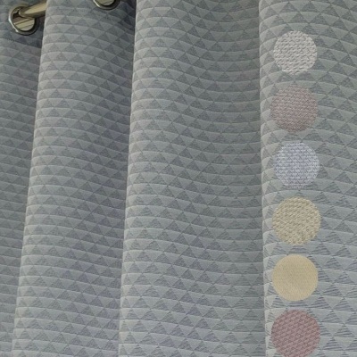 Cortina cinzenta com padrão triangular e argolas metálicas num varão