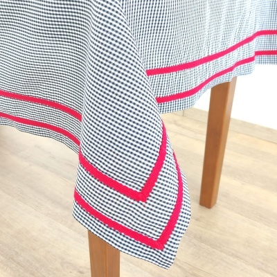 Toalha de mesa xadrez azul e branco com linhas vermelhas na borda