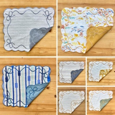 Jogos de panos de cozinha com várias estampas e bordados sobre fundo de madeira