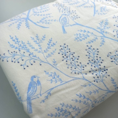 tecido branco com padrão azul de ramos e pássaros
