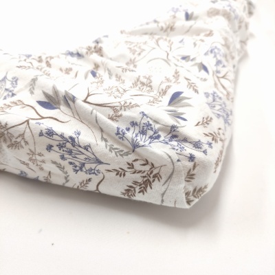 tecido branco com padrão floral azul e castanho com pregas