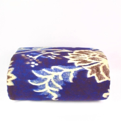 Manta dobrada com padrão floral azul, bege e castanho