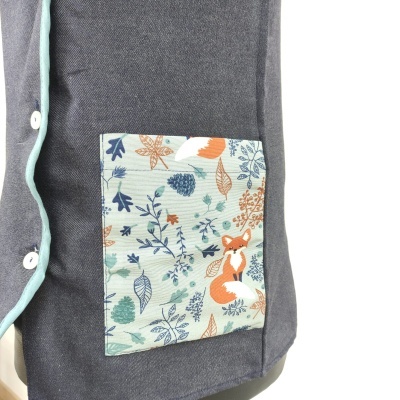 Peça de roupa cinza escuro com bolso estampado com raposa e folhas em tecido claro