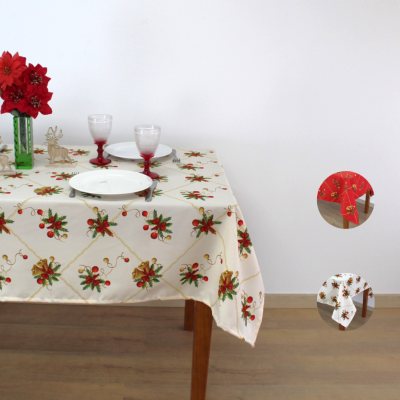 Toalha de mesa natalícia creme com ramos de azevinho e fitas douradas sobre mesa de madeira