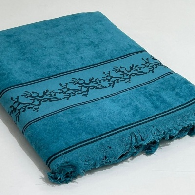 Toalha azul turquesa com padrão preto e franjas sobre fundo branco