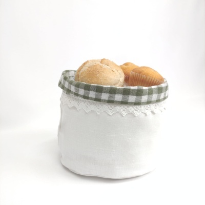cesto de tecido branco com pão e bolos dentro