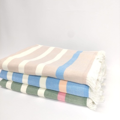 três mantas às riscas em tons pastel com franjas
