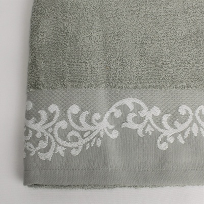 Toalha cinzenta com padrão branco decorativo na borda inferior
