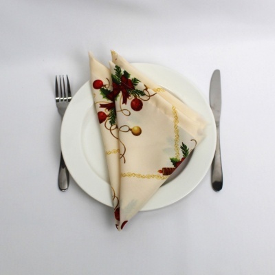 Guardanapo decorativo de Natal sobre prato branco com talheres