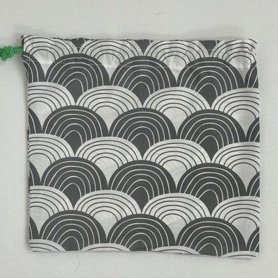 Saco de tecido com padrão preto e branco e cordão verde