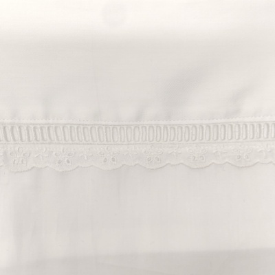 Tecido branco com bordado em renda e padrão ondulado na borda