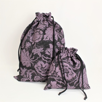 Dois sacos de tecido com padrão floral lilás em fundo preto