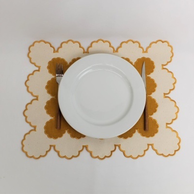 Individual de mesa quadrado com padrão floral castanho e branco, prato branco e talheres