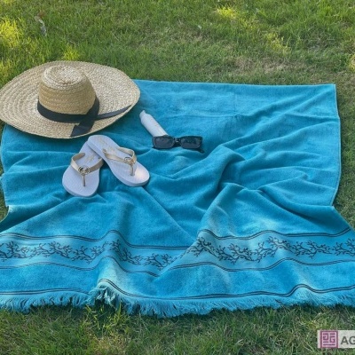 Toalha de praia azul com acessórios de verão sobre relvado