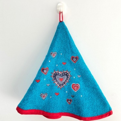 Toalha triangular azul com corações vermelhos e cinza pendurada na parede