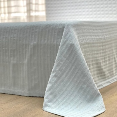 colcha branca com padrão texturizado em cama