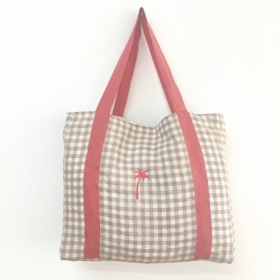 Mala com padrão xadrez bege e branco e alças rosas com bordado de palmeira