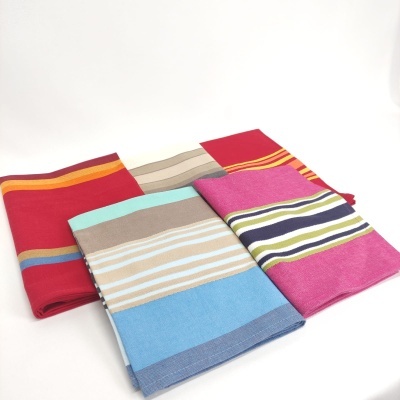 Três toalhas coloridas com riscas horizontais dobradas sobre fundo branco