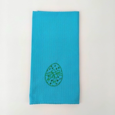 Toalha azul claro com bordado verde de ovo da páscoa