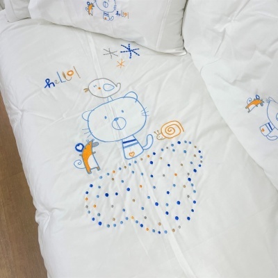 Colcha infantil branca com bordados de animais coloridos e almofadas correspondentes