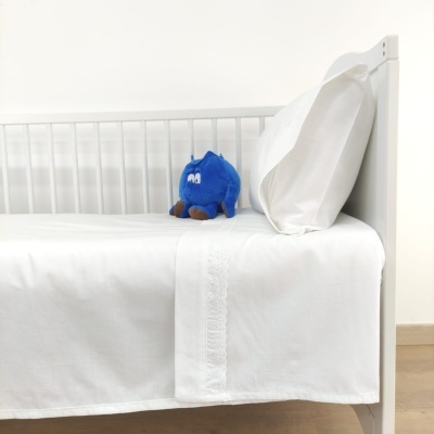 Cama branca com roupa de cama branca e peluche azul
