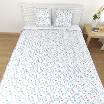 Cama de casal com roupa de cama branca com padrão floral e cabeceira acolchoada branca