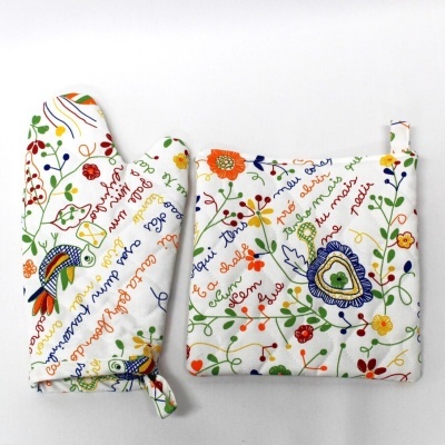 Luva e pega para panela em tecido branco com padrão colorido de flores e texto